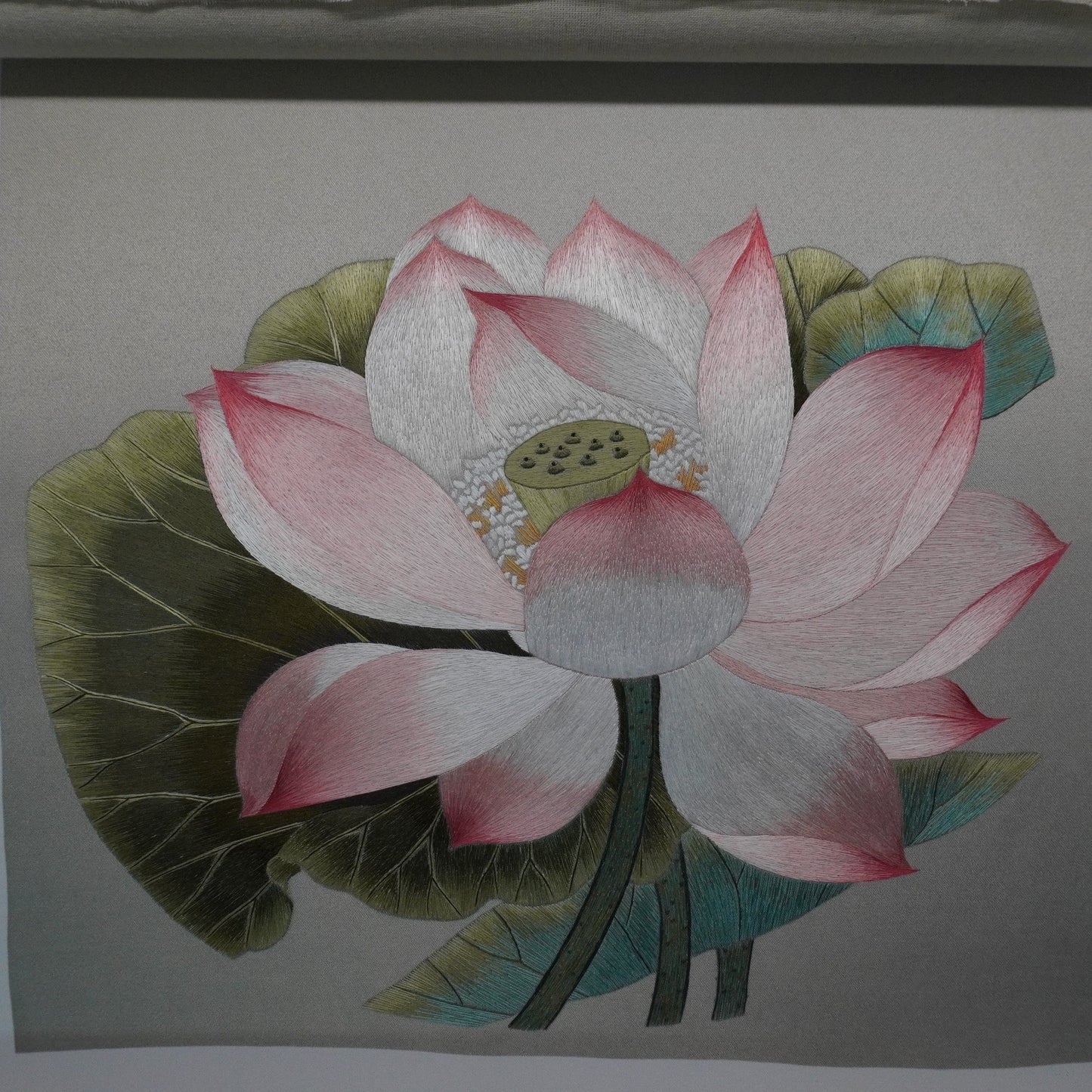 Close-up of Canton embroidery of Song Dynasty lotus painting. Hand-embroidered silk art in silver frame, 50.5cm square with glass.