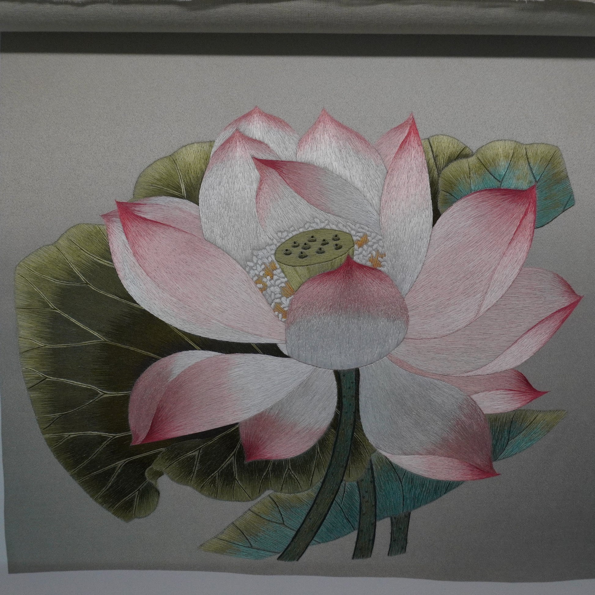 Close-up of Canton embroidery of Song Dynasty lotus painting. Hand-embroidered silk art in silver frame, 50.5cm square with glass.