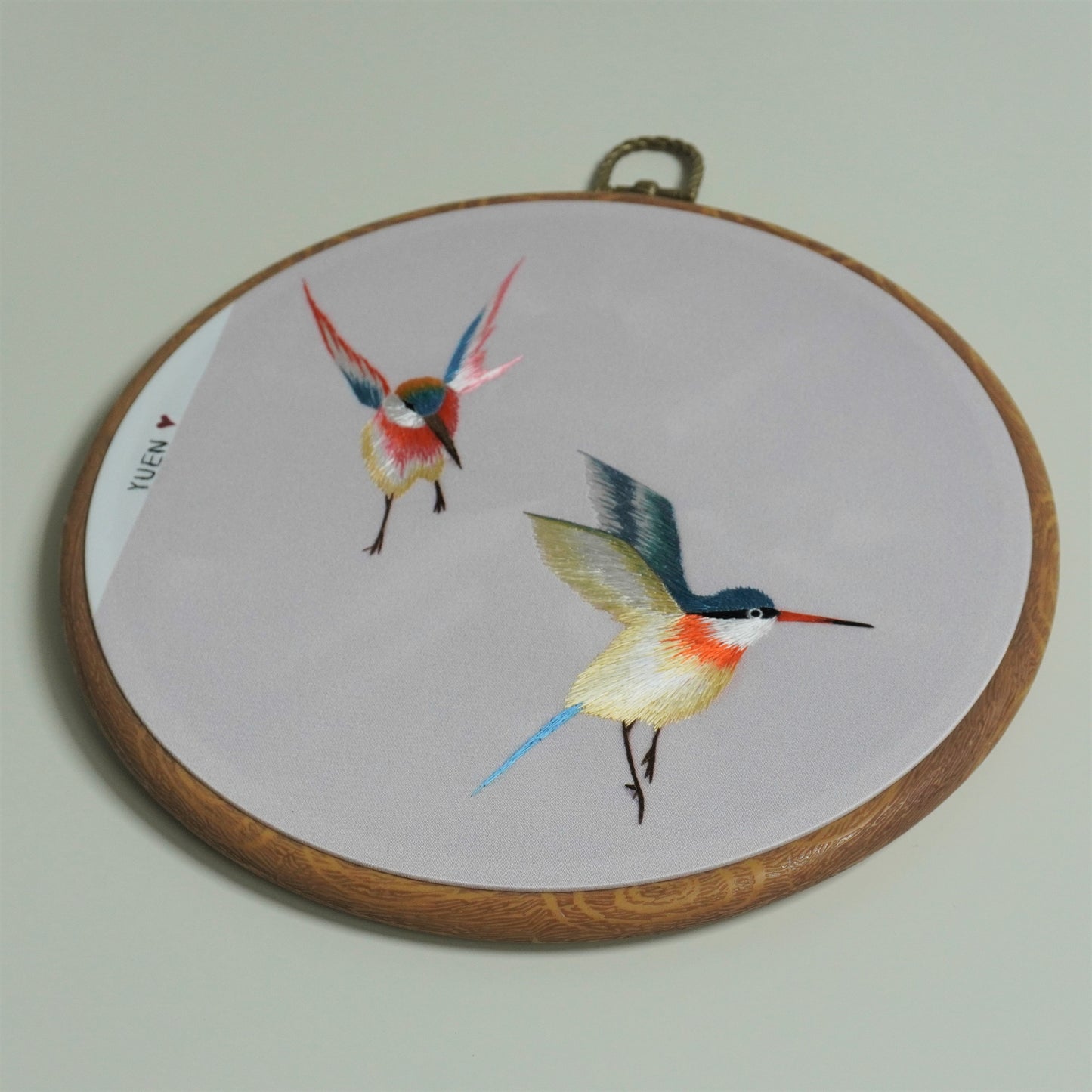 Details of colorful hummingbird hand-embroidery hoop art