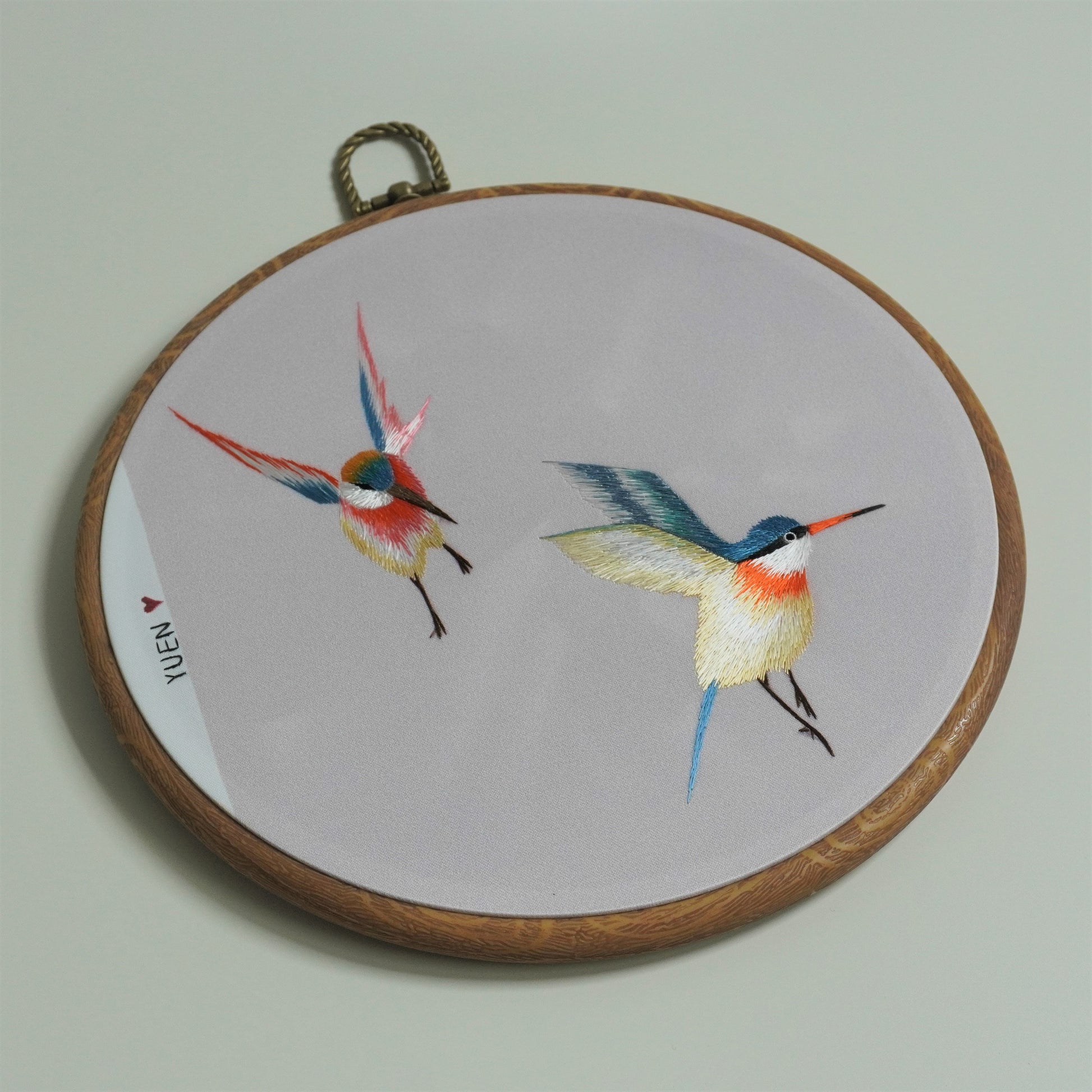 Close-up of colorful hummingbird hand-embroidery hoop art