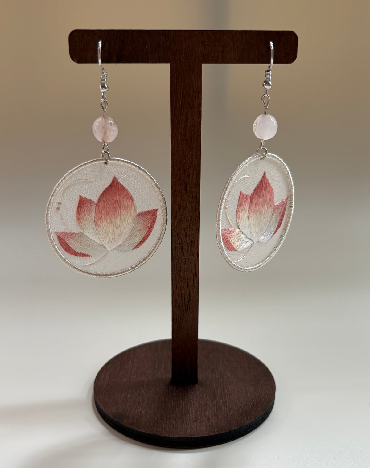 Hand-embroidered lotus earrings with a pink-to-white gradient.