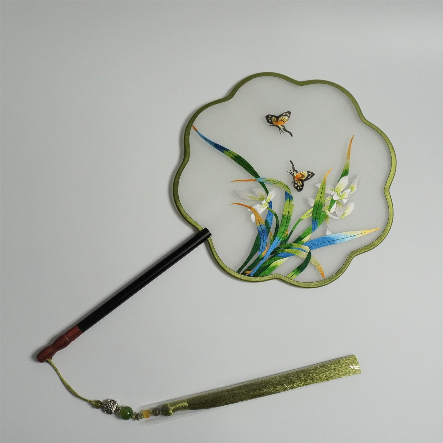 Hand-embroidery orchid and butterfly on silk gauze fan. Plum blossom shaped frame with redwood handle, jade bead tassel.