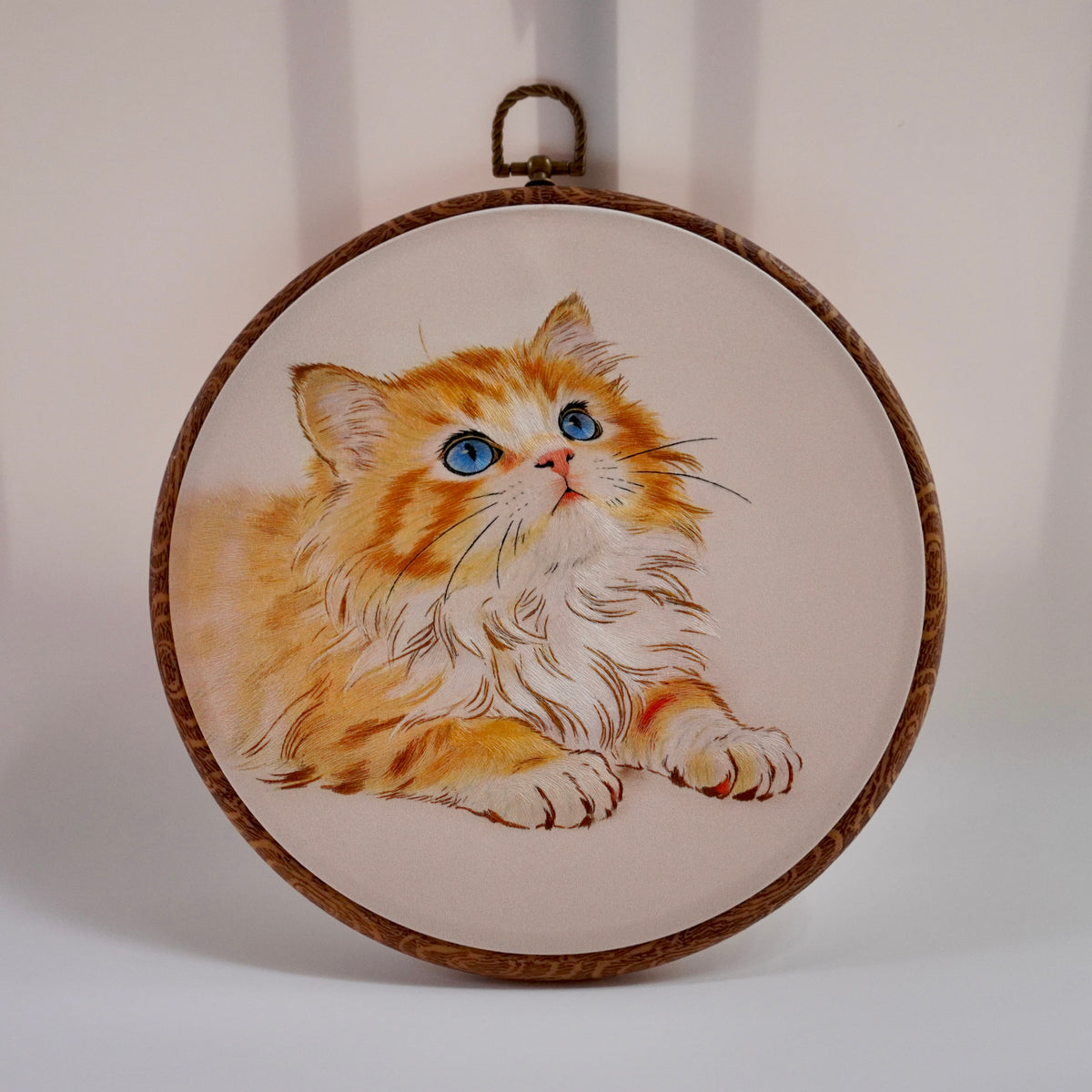 Hand-embroidered golden shaded cat in round hoop, front view, silk thread wall art