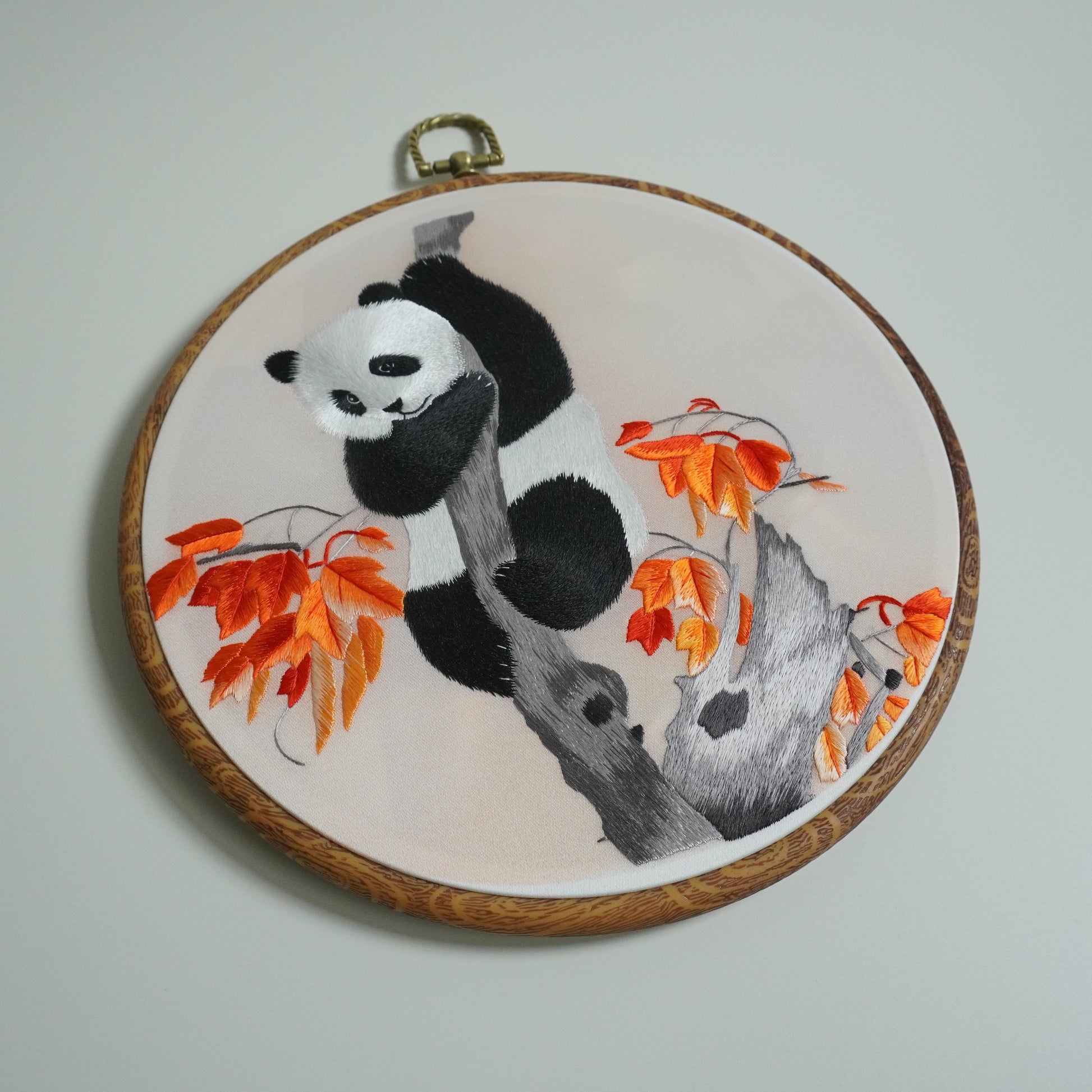 Hand-embroidered panda climbing maple tree branch on round faux-wood hoop. Wall Art.