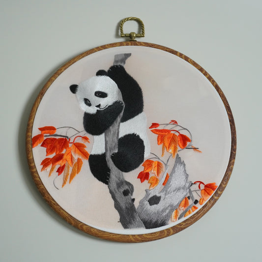 Hand-embroidered panda climbing maple tree branch on round faux-wood hoop. 20cm silk embroidery wall art.