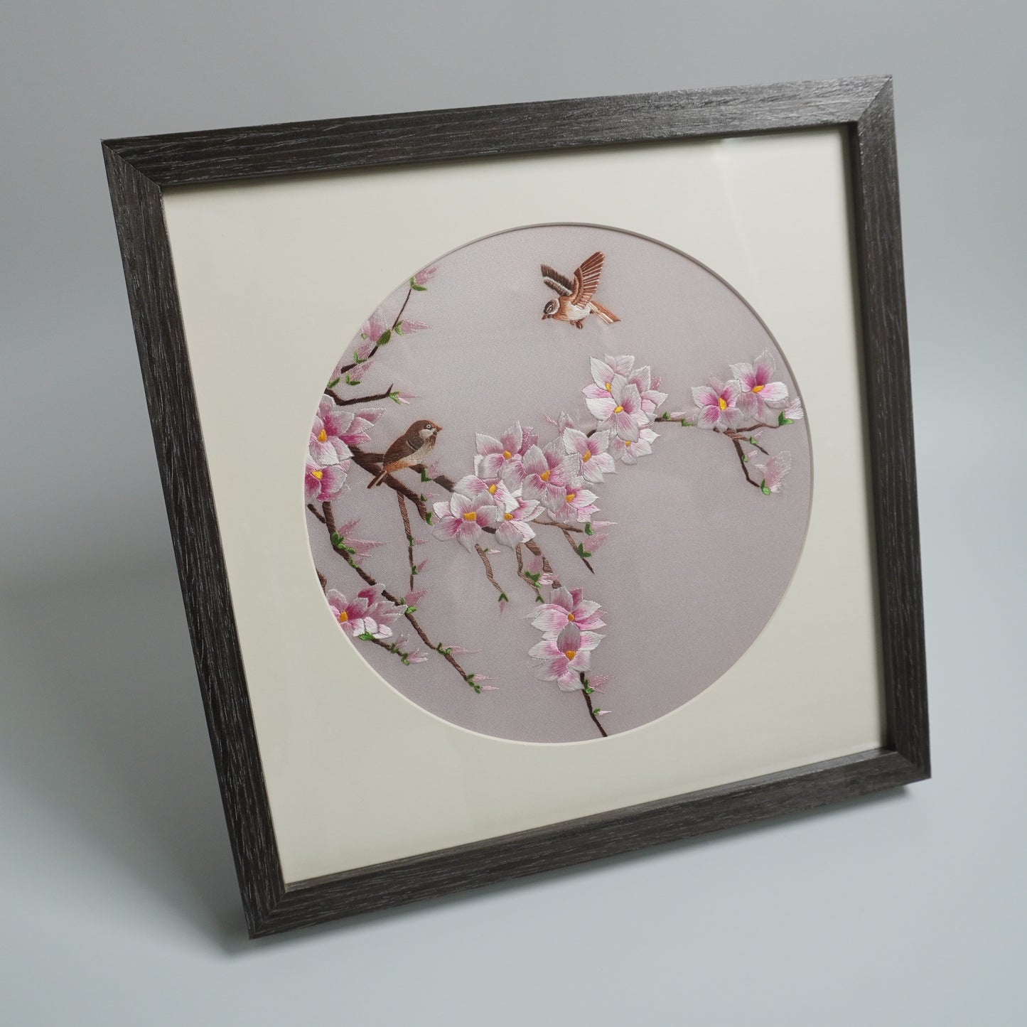 Hand-embroidered magnolia and birds in black wood side view