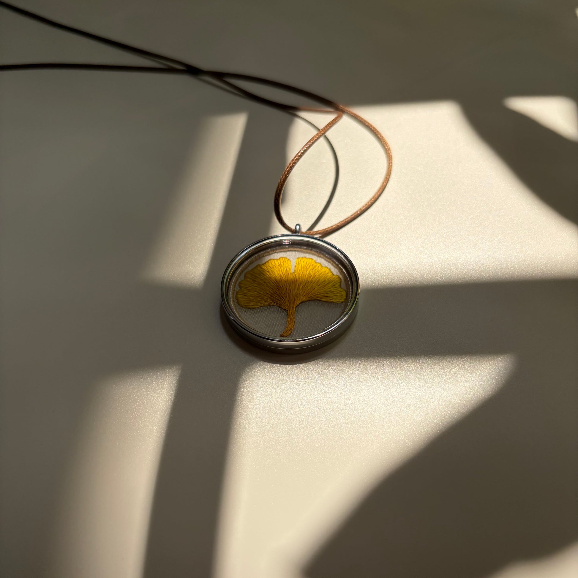 Embroidered ginkgo leaf pendant in the sunlight